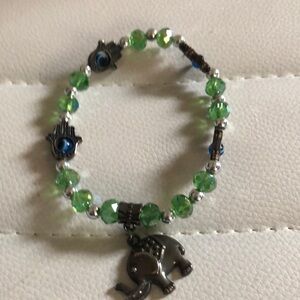 Green beaded bracelet with elephant charm and hand charms
